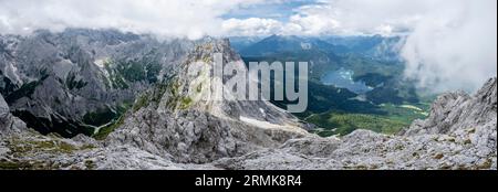 Panorama, Blick vom Gipfel des Waxensteins über den felsigen und schmalen Kamm des Waxensteins zum Eibsee und Hoellental, bewölkt Stockfoto