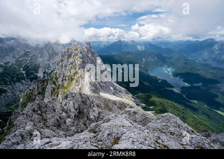 Blick vom Gipfel des Waxensteins über den felsigen und schmalen Kamm des Waxensteins zum Eibsee, bewölkte felsige Bergwelt Stockfoto