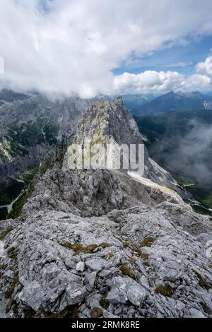 Blick vom Gipfel des Waxensteins über den felsigen und schmalen Bergrücken des Waxensteins, bewölkte felsige Bergwelt, Wettersteingebirge Stockfoto