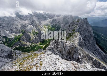 Blick vom Gipfel des Waxensteins über den felsigen und schmalen Bergrücken des Waxensteins zum Hoellental mit Jubilaeumsgrat, bewölktem felsigem Berg Stockfoto