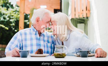 Ein älteres Paar sitzt mit Kopf und trinkt Tee Stockfoto