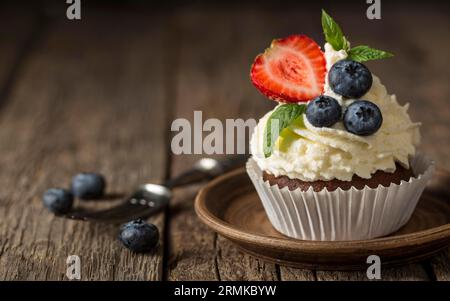 Vorderansicht leckerer Cupcake mit Erdbeer-Heidelbeere Stockfoto