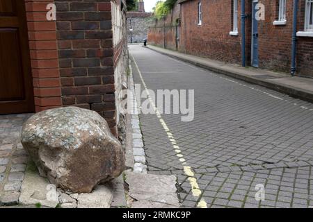 Moot Stone, außerhalb eines modernen Hauses, das auf und um die Basis eines alten Hauses an der Ecke von St Thomas Street und Minster Lane gebaut wurde. Bild mit Blick auf die Minster Lane. Winchester, Hampshire, England 2023. Stockfoto