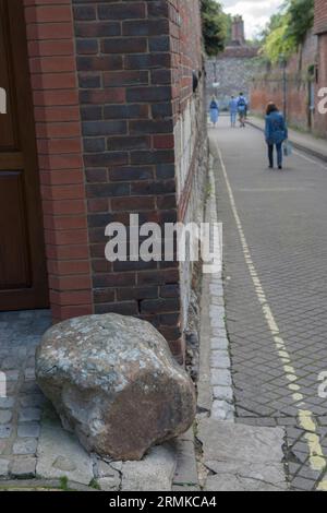 Moot Stone, außerhalb eines modernen Hauses, das auf und um die Basis eines alten Hauses an der Ecke von St Thomas Street und Minster Lane gebaut wurde. Bild mit Blick auf die Minster Lane. Winchester, Hampshire, England 2023. Stockfoto