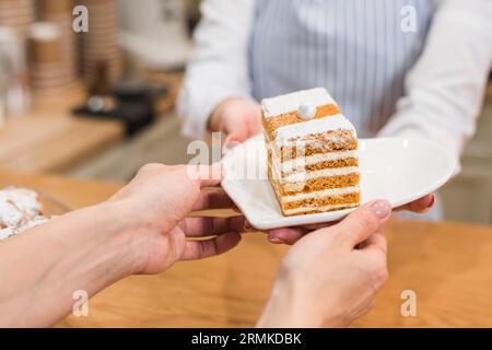 Kellnerin serviert Gebäck weißen Teller Kunden Stockfoto