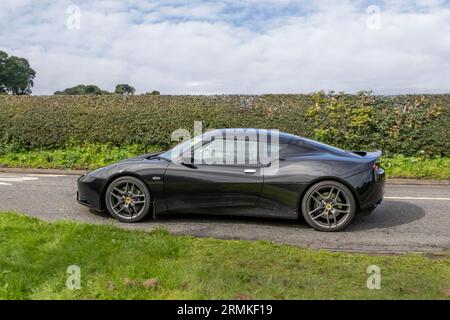 2010 Lotus Evora 4 V6 Black Car Coupe Benzinmotor mit 3456 ccm, Kompressor und Ladeluftkühler, DOHC, 24 Ventilen, V-6, ausgestattet mit einem mittig montierten, querverlaufenden, von Toyota stammenden 3,5-Liter-2GR-V6-Motor mit 24 Ventilen. Stockfoto