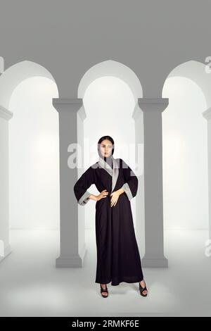 Asian Model posiert für den arabischen Designer Abaya auf isoliertem Hintergrund. Modekonzept Stockfoto