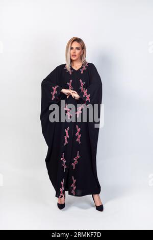 Asian Model posiert für den arabischen Designer Abaya auf isoliertem Hintergrund. Modekonzept Stockfoto