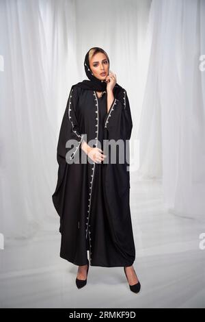 Asian Model posiert für den arabischen Designer Abaya auf isoliertem Hintergrund. Modekonzept Stockfoto