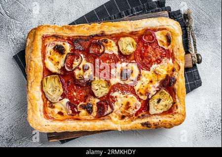 Vegetarische Blätterteigpizza mit Artischocke, Mozzarella, Tomaten und Käse. Weißer Hintergrund. Draufsicht. Stockfoto