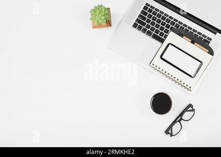 Tasse Kaffee mit Laptop-Handy-Tagebuch mit Stift weißen Hintergrund Stockfoto