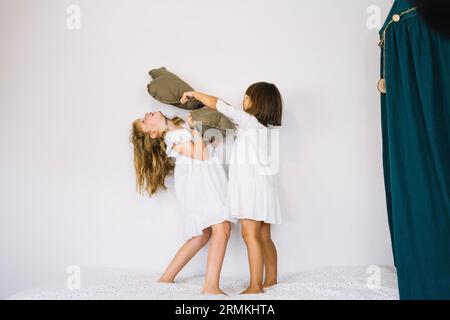 Mädchen schlagen sich mit Kissen Stockfoto