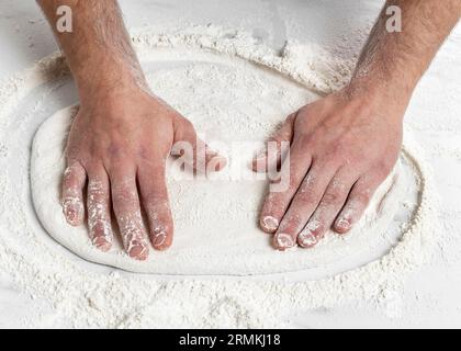 Mann mit hohem Winkel knetet Pizzateig Stockfoto