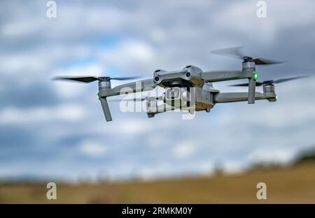 Eine DJI Air 2S-Drohne, die tief auf dem Boden liegt, während sie beim Filmen schwebt Stockfoto