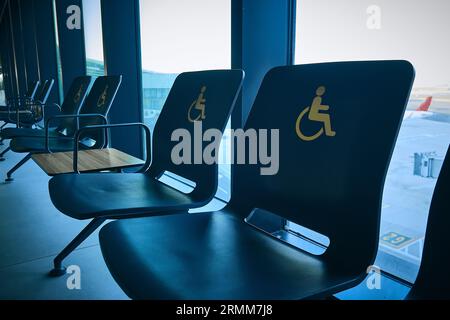 Leere Prioritätssitze für Menschen mit Behinderungen. Stühle für Behinderte am Flughafen Stockfoto