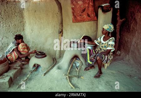 Mali, Dioila. Frauen, die Lebensmittel auf einem traditionellen Tonofen zubereiten. Auf diese Weise wird Holz gespart, verglichen mit dem Kochen auf offenem Feuer. Stockfoto