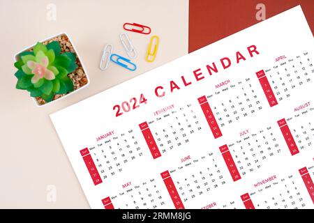 Kalender 2024 Seite mit Büroklammer und Pflanztopf auf schönem Hintergrund. Stockfoto