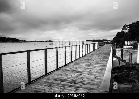 Alte hölzerne Anlegestelle auf dem Fluss Mira an einem bewölkten Tag in Vilanova de Milfontes, Alentejo, Portugal Stockfoto