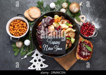 Gebackenes, geröstetes, gegrilltes Gemüse in der Pfanne auf dunklem Hintergrund. Rote Bete, Karotte, Pilze, Kürbis und rosenkohl. Weihnachtliches Mittagessen, vegetarisch Stockfoto