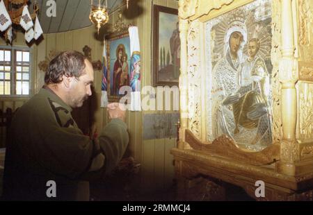 Kloster Rarau, Kreis Suceava, Rumänien, ca. 2000. Der Mann, der das Kreuz vor der orthodoxen Ikone macht, die die Mutter Gottes mit dem Heiligen Kind darstellt, gilt als WunderwerkIkone. Stockfoto