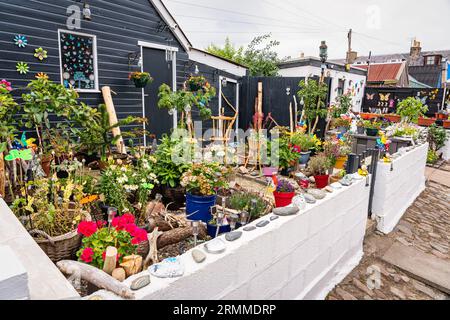 Kleine Häuser mit farbenfroher Dekoration in den Gärten im Fischerviertel Footdee, Aberdeen, Großbritannien. Stockfoto