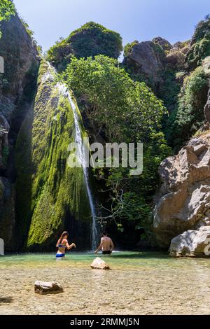 Wanderer, die sich unter einem kleinen Wasserfall am Ende der Richtis-Schlucht im Osten Kretas, Griechenland, abkühlen Stockfoto