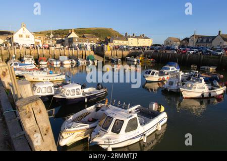 Boote legen bei Sonnenuntergang im Hafen von West Bay an; Küstenlandschaft von West Bay Dorset UK. Stockfoto