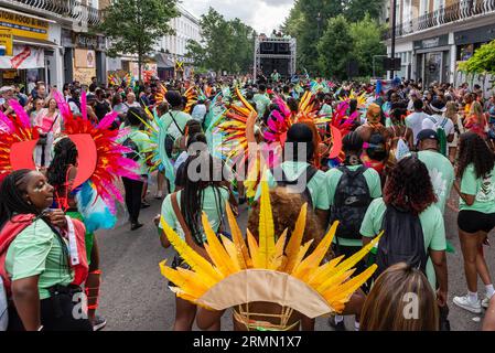 Öffentlichkeit und Teilnehmer auf der Straße nach einem Sound-System-Truck bei der Notting Hill Carnival Grand Parade 2023 in London, Großbritannien. Befahrene Straße Stockfoto