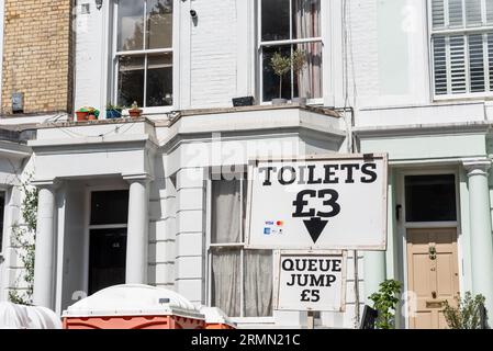 Gäste, die Toiletten in ihrer Anlage bei der Notting Hill Carnival Grand Parade 2023, London, Großbritannien, anbieten. Option Warteschlangensprung gegen zusätzliche Gebühr Stockfoto