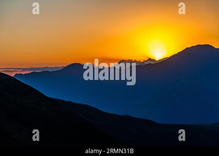 Auf der Khevsureti-Seite des Atsunta-Passes in Georgien. Bei Sonnenuntergang können Sie weit hinter dem Gebirge den Berg Kasbek sehen Stockfoto