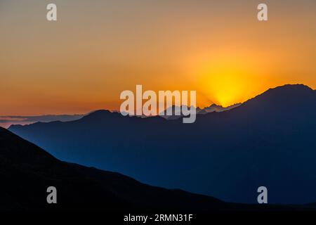 Auf der Khevsureti-Seite des Atsunta-Passes in Georgien. Bei Sonnenuntergang können Sie weit hinter dem Gebirge den Berg Kasbek sehen Stockfoto