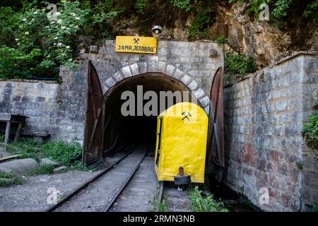 Eingangstor zum Kohlebergwerk, das tief in die Erde führt. Grubenschacht des Kohlebergwerks, in der Nähe der Stadt Despotovac und Resavska Pecina, Serbien, mit Bergbausymbol Stockfoto