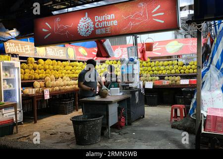 Ein Durianer-Verkäufer schneidet die stechenden tropischen Früchte an einem Stall im Geylang-Viertel Singapurs. 24/09/2022 Stockfoto