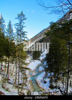 Malerischer Blick auf einen Fluss, der durch das Vrata-Tal im Triglav-Nationalpark und die Julischen alpen fließt, Gorenjska Slowenien im Winter Stockfoto