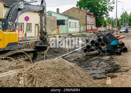 Blick auf den Straßenumbau mit tiefem Graben, alten und neuen unterirdischen Rohren, neuem vertikalen Kunststoffbrunnen Stockfoto