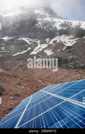 Nahaufnahme von Solarpaneelen mit Chimborazo-Vulkan im Hintergrund, selektiver Fokus, Ecuador. Stockfoto