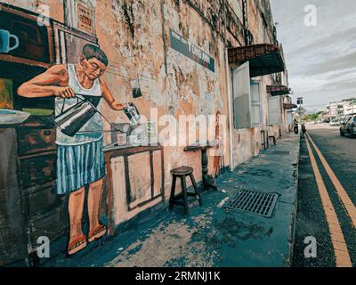Ein lebendiges Wandgemälde ist an der Seite eines Gebäudes entlang einer belebten Straße gemalt und hat ein helles und auffälliges Design Stockfoto