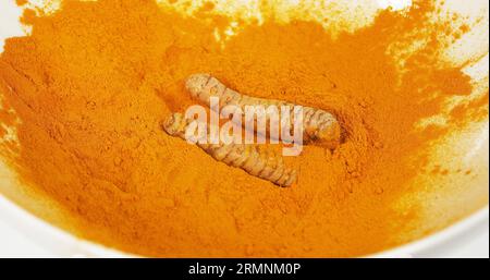 Kurkuma, Kurkuma longa, Wurzel fällt auf Kurkuma Pulver, indische Gewürze Stockfoto