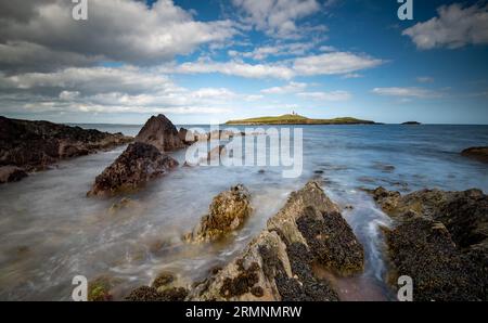 Felsküste aus Bellycotton mit Leuchtturm für die Meeressicherheit in Irland. Stockfoto