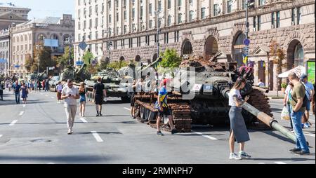 Kiew, Ukraine. August 2023. Die Bewohner und Gäste der ukrainischen Hauptstadt spazieren entlang der Chreshchatyk-Straße im Zentrum der ukrainischen Hauptstadt und sehen zerstörte russische Militärausrüstung, die anlässlich des Unabhängigkeitstages der Ukraine ausgestellt wird. Anlässlich des Unabhängigkeitstages der Ukraine wurde eine „Parade“ von zerbrochener russischer Ausrüstung auf Chreschtschatsch in Kiew veranstaltet. Auf Chreschatsch im Zentrum von Kiew wurden verbrannte Panzer, gepanzerte Fahrzeuge und Fragmente russischer Raketen ausgestellt. So feierte die ukrainische Hauptstadt am 24. August den Unabhängigkeitstag. (Bild: © Mykhaylo Palinchak/SOPA Images Stockfoto