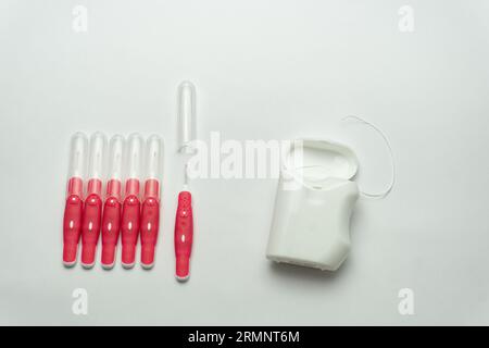 Interdentalbürstenstifte und Zahnseide auf weißem Hintergrund, Kopierraum Stockfoto