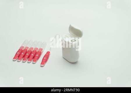 Interdentalbürstenstifte und Zahnseide auf weißem Hintergrund, Kopierraum Stockfoto