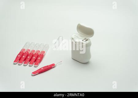 Interdentalbürstenstifte und Zahnseide auf weißem Hintergrund, Kopierraum Stockfoto
