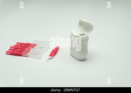 Interdentalbürstenstifte und Zahnseide auf weißem Hintergrund, Kopierraum Stockfoto