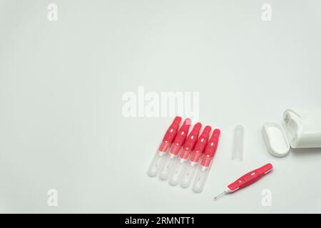 Interdentalbürstenstifte und Zahnseide auf weißem Hintergrund, Kopierraum Stockfoto