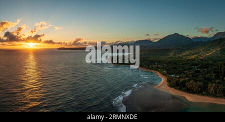 Dramatisch breites Panorama, das von Tunnels Beach auf Kauai in Richtung Osten in Richtung aufgehende Sonne und Hanalei Bucht blickt Stockfoto