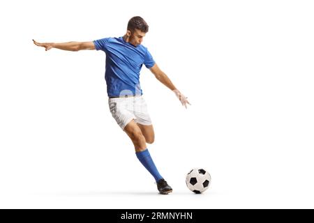 Fußballspieler in einem blauen Trikot läuft und bereitet sich darauf vor, einen Ball isoliert auf weißem Hintergrund zu treten Stockfoto