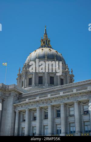 San Francisco, CA, USA - 12. Juli 2023: Fassade des NE City Hall aus grauem Stein und riesige Kuppel unter blauem Himmel. Goldene Dekoration an und auf dem Turm. Stadt fl Stockfoto