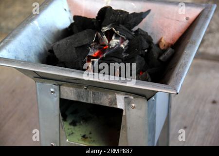 Holzkohlestücke auf einem Grillherd, die ein Feuer zum Kochen oder Braten von Fleisch anzünden Stockfoto