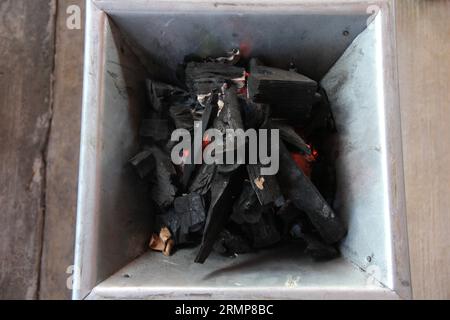Holzkohlestücke auf einem Grillherd, die ein Feuer zum Kochen oder Braten von Fleisch anzünden Stockfoto